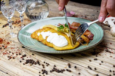 Kızarmış pastırmalı adam, patatesli mantar krep ve votka.
