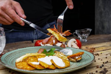 Kızarmış pastırmalı erkek elleri, patatesli mantarlar ve votka.