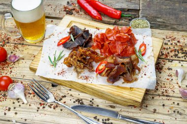 Tuzlanmış et türünde bira aperatifi ve bir bardak bira. 