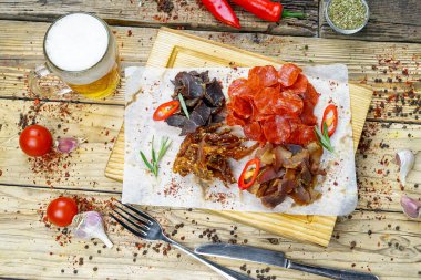 Tuzlanmış et türünde bira aperatifi ve bir bardak bira. 