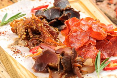 Ahşap masada tuzlanmış et türündeki bira aperatifleri..