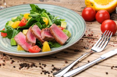 Avokado salatası, çatal, bıçak ve domatesli ton balığı.
