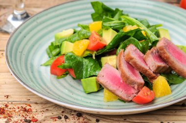 Avokado salatalı ton balığı ve arka planda domates, yakın plan.