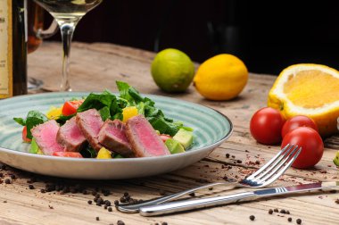 Avokado salatası, çatal, bıçak ve domatesli ton balığı.