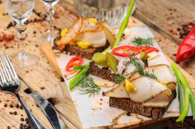 Domuz yağı, hardal, salatalık turşusu, biber ve soğanlı ekmek. 