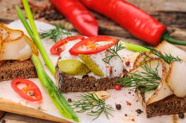 Domuz yağı, hardal, salatalık turşusu, biber ve soğanlı ekmek. 