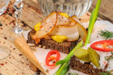 Domuz yağı, hardal, salatalık turşusu, biber ve soğanlı ekmek.