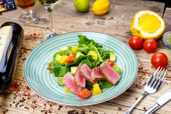 Avokado salatası, çatal ve bıçak, şarap ve domatesli ton balığı. 