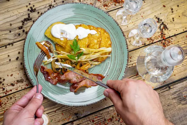 Kızarmış pastırmalı adam, patatesli mantar krep ve votka.