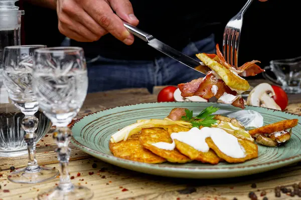 Kızarmış pastırmalı erkek elleri, patatesli mantarlar ve votka.