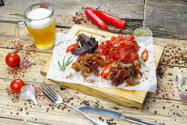 Bira ve tuzlanmış et türünde bira aperatifleri bir bardak bira ve biberle birlikte.