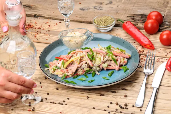 Jambon, soğan, salatalık ve salata soslu taze salata ile kadın elleri. 