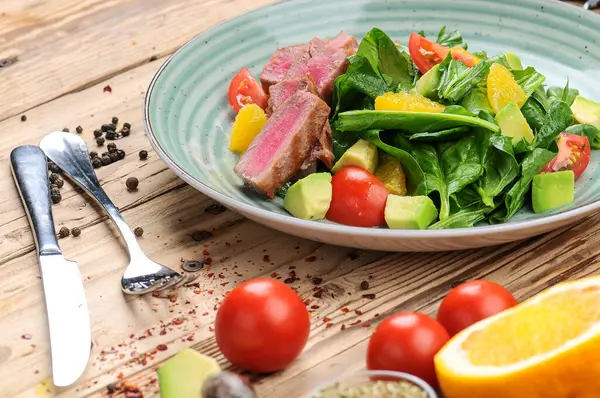 Avokado salatası, çatal, bıçak ve domatesli ton balığı.