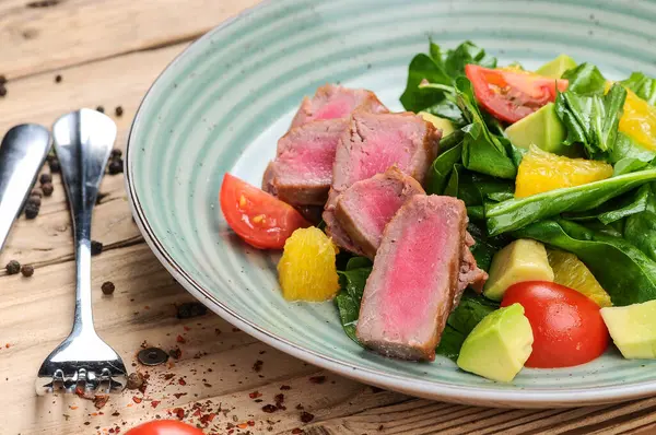 Avokado salatası, çatal, bıçak ve domatesli ton balığı.