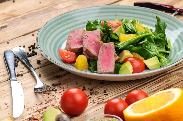 Avokado salatası, çatal, bıçak ve domatesli ton balığı.