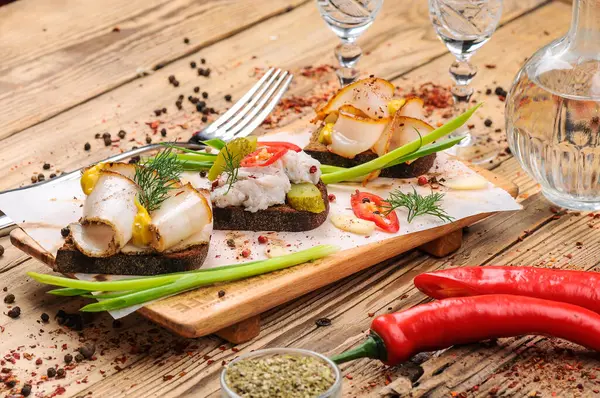 Domuz yağlı ekmek, hardal, salatalık turşusu, kırmızı biber ve soğan arka planda, kapat.