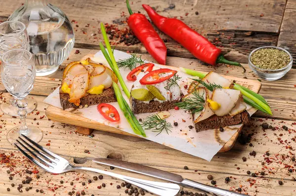 Yağlı ekmek, hardal, salatalık turşusu, biber ve soğan, arka planda, kapat.