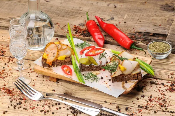 Yağlı ekmek, hardal, salatalık turşusu, biber ve soğan, arka planda, kapat.