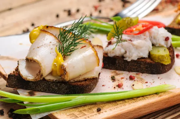 Domuz yağlı ekmek, hardal, salatalık turşusu ve soğan.