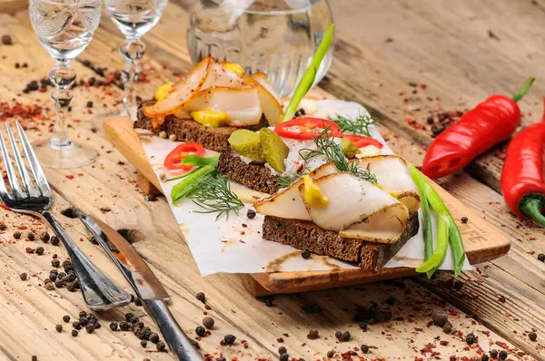 Yağlı ekmek, hardal, salatalık turşusu, biber ve soğan, arka planda, kapat.