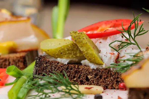 Domuz yağlı ekmek, hardal, salatalık turşusu ve soğan.