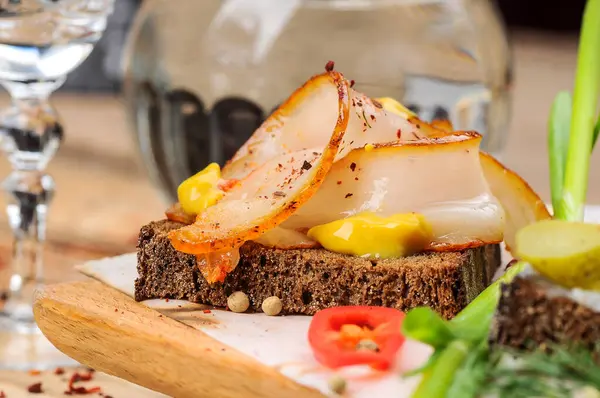 Domuz yağlı ekmek, hardal, salatalık turşusu ve soğan.