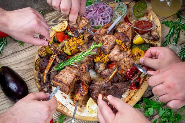 Kızarmış etli kebap ve sebzeli eller. 