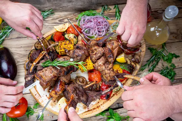 Kızarmış etli kebap ve sebzeli eller. 