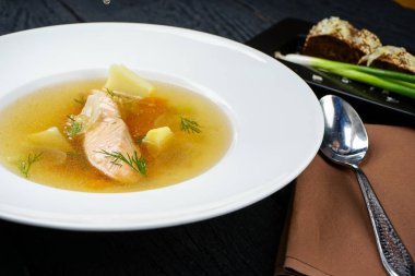 Patatesli somon çorbası, ekmek ve kaşık.