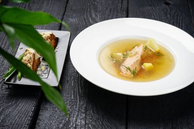 Beyaz tabakta patates ve somon çorbası.