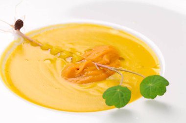 Tabakta yeşil yapraklı lezzetli sarı çorba.