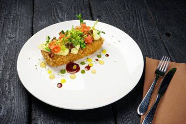 Kırmızı somonlu ev yapımı sandviç ve bıçaklı çatal.