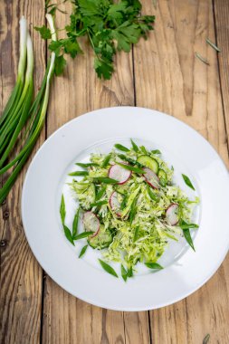 Salata taze lahana, turp, soğan ve ahşap zemin üzerinde biberiye.