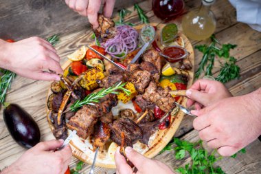 Arka planda sebzeli eller ve et kebabı ve alkollü içecekler, kapatın.