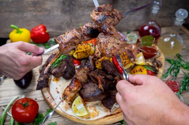 Lezzetli kızarmış et kebabı sebzeli ve taze içecekli eller.