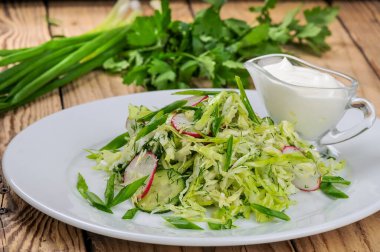 Taze lahana salatası, turp ve ahşap zemin üzerinde soğan.