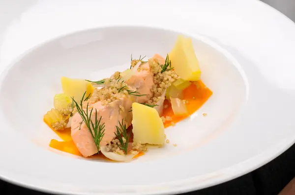 Beyaz tabakta patatesli somon çorbası 