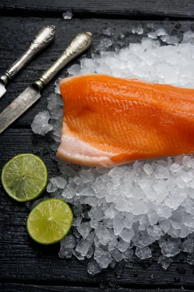 Siyah masada limonlu ve buzlu çiğ somon.