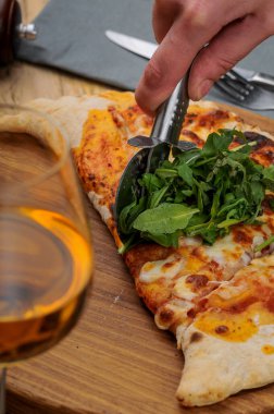 Adam peynirle calzone kesiyor.