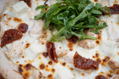 Domatesli geleneksel pizza, arka planda peynir, kapat.