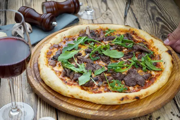 Lezzetli İtalyan pizzası ve et ve şarapla el.