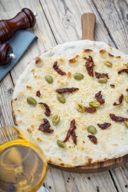 Peynirli ev yapımı pizza ve şaraplı zeytin.