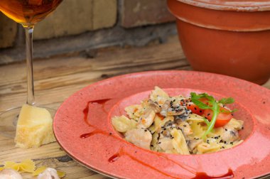  Mantarlı makarna ve arka planda şaraplı peynir, yakın plan.