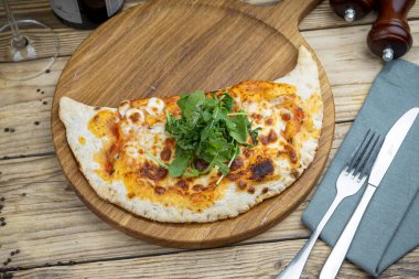 Tahtada peynir olan lezzetli pizzanın üst görüntüsü.