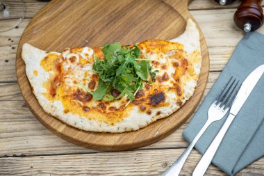 Tahtada peynir olan lezzetli pizzanın üst görüntüsü.