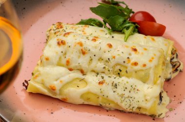 Lezzetli İtalyan Cannelloni. Kızarmış mantarla doldurulmuş. Peynirli kremalı sos.