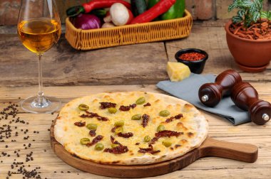 Peynirli, zeytinli ve ançüezli İtalyan pizzası.