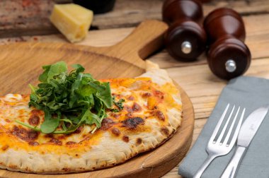 Güneşte kurutulmuş domatesli, peynirli ve yeşillikli pizza manzarası.