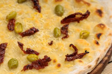 Güneşte kurutulmuş domates ve peynirli pizzanın yakın görüntüsü.