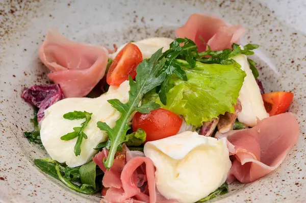 Jambonlu taze domates salatası, mozarella peyniri ve roka.